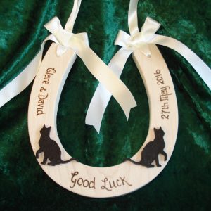 Lucky Black Cat Wedding Horseshoe . Solid sycamore wedding horseshoe with two wooden lucky black cats added to the front. Personalised with names, date and Good Luck. Finished with luxury satin ribbon bows and carrying loop